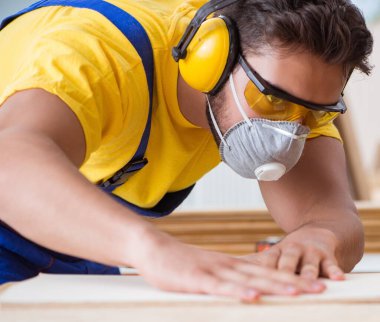 Daire testere ile çalışan genç marangoz.