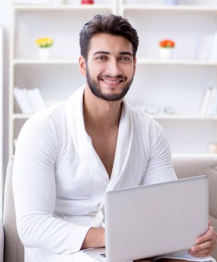 Evde dizüstü bilgisayarla çalışan serbest çalışan genç adam.