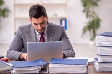 Genç bir çalışan ve ofiste çok fazla iş var.