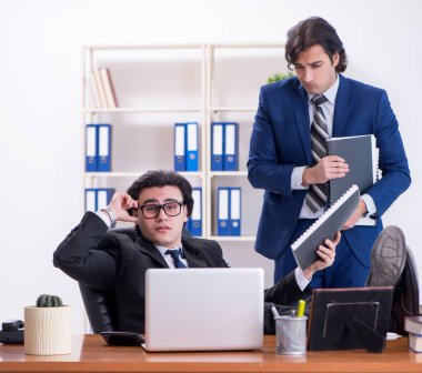 Patron ve erkek asistanı ofiste çalışıyor.