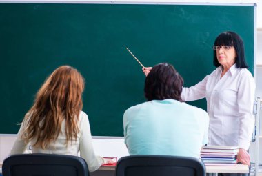 Eski öğretmen ve öğrenciler sınıfta.