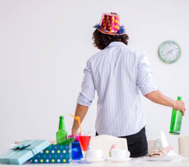 Genç adam doğum gününü evde kutluyor.