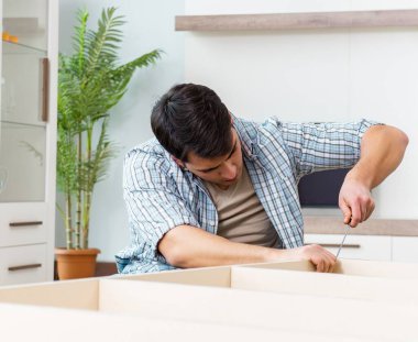 Evde mobilya montajı yapan adam.