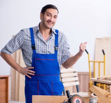 İçeride çalışan genç erkek marangoz.