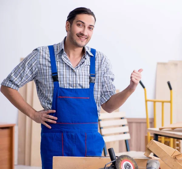 İçeride çalışan genç erkek marangoz.