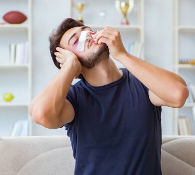 Genç adam estetik ameliyattan sonra evde iyileşiyor.