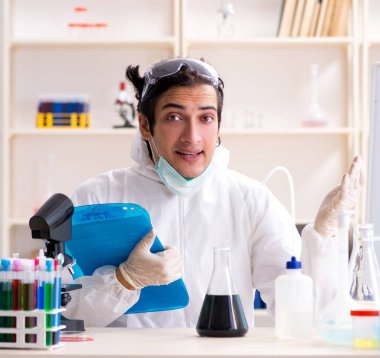 Laboratuvarda çalışan genç yakışıklı kimyager.