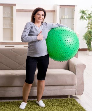 Yaşlı hamile kadın evde egzersiz yapıyor.