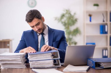 Genç işadamı ve ofiste çok fazla iş var.