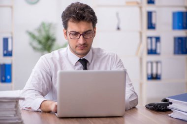 Young employee and too much work at workplace