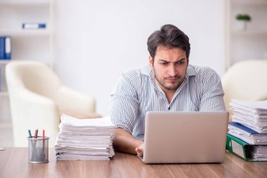 Young employee and too much work at workplace