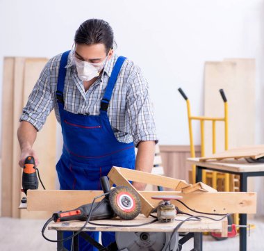 İçeride çalışan genç erkek marangoz.