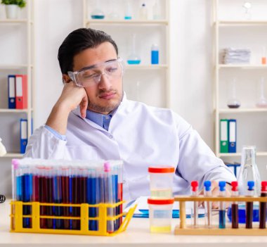 Laboratuvarda çalışan genç erkek kimyager.