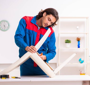 Mobilya montajında çalışan genç marangoz.