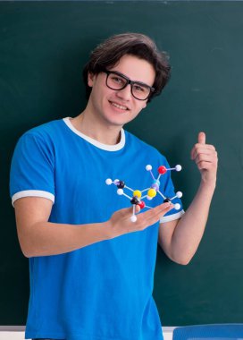 Sınıftaki genç erkek öğrenci.