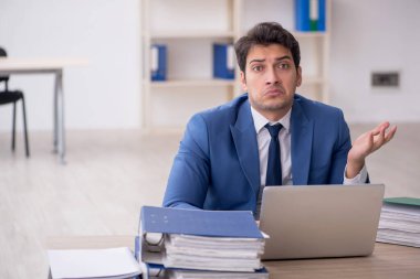 Genç işadamı ve işyerinde çok fazla iş var.