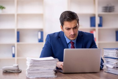 Genç işadamı ve işyerinde çok fazla iş var.