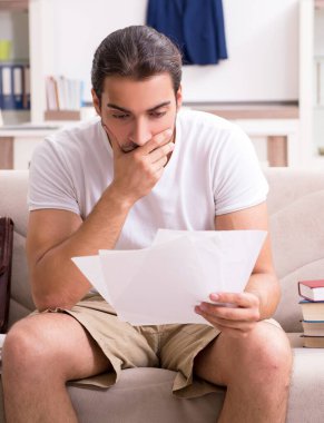 Genç erkek öğrenci evde sınavlara hazırlanıyor.