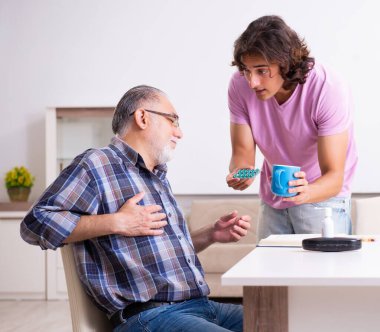 Genç öğrenci ve yaşlı büyükbabası evde.