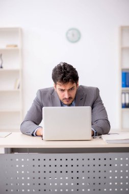 Genç bir çalışan ve ofiste çok fazla iş var.