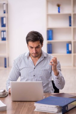 Genç işadamı işyerinde oturuyor.