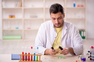 Young chemist sitting at the lab