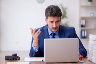 Genç bir çalışan ve ofiste çok fazla iş var.