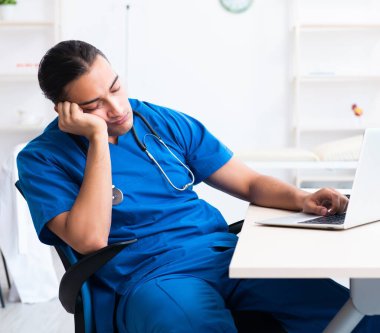 Klinikte çalışan genç erkek doktor.