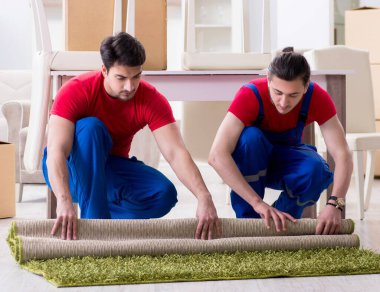 İki müteahhit personel kişisel eşyalarını taşıyor.