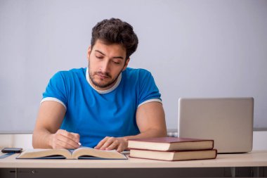 Genç öğrenci beyaz tahtanın önünde.
