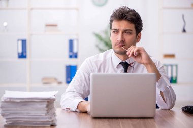 Young employee and too much work at workplace