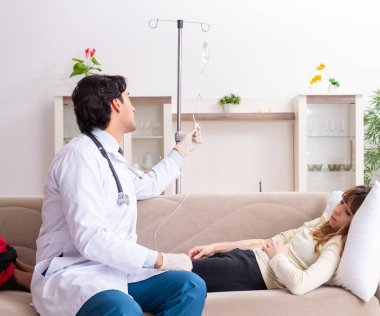 Genç, yakışıklı doktor, kadın hastayı evinde ziyaret ediyor.