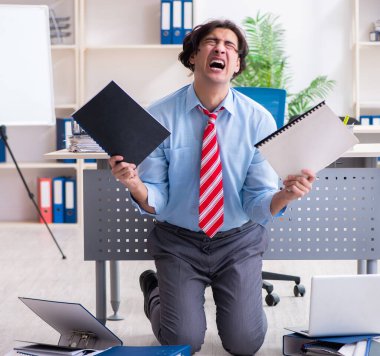 Genç erkek çalışan aşırı işten memnun değil.