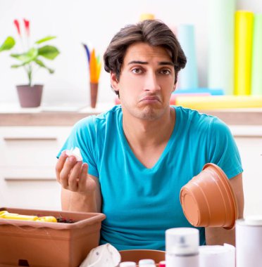 Sınıfta çömlek dekore eden genç adam.