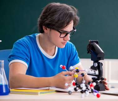 Sınıftaki genç erkek öğrenci.