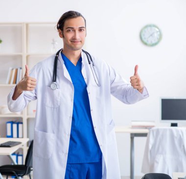 Klinikte çalışan genç erkek doktor.