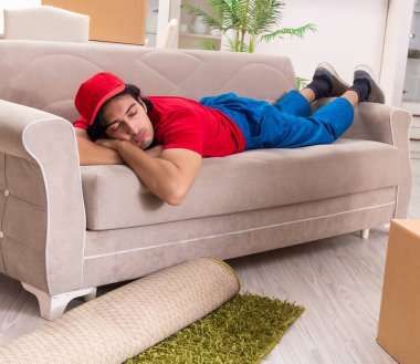 İçeride çalışan kutularla çalışan genç bir erkek müteahhit.