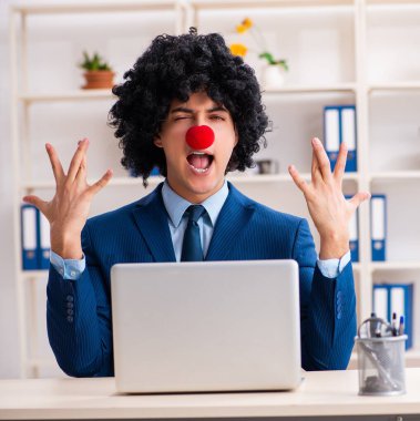 Ofiste çalışan genç palyaço işadamı.