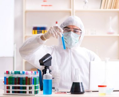 Laboratuvarda çalışan genç yakışıklı kimyager.