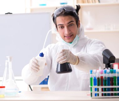 Laboratuvarda çalışan genç yakışıklı kimyager.