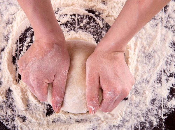 The cook preparing dough for baking in the kitchen