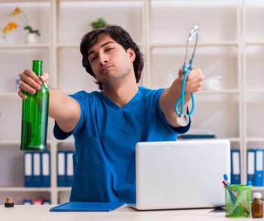 Ofiste içen genç erkek doktor.