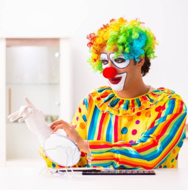 Erkek palyaço evde performansa hazırlanıyor.