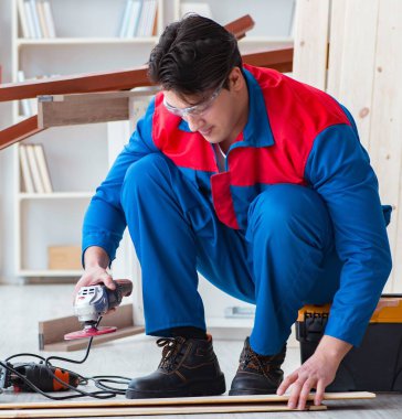 Genç marangoz tahta kalaslarla çalışıyor.