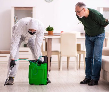 Genç erkek dezenfektan ve evde yaşlı bir adam.