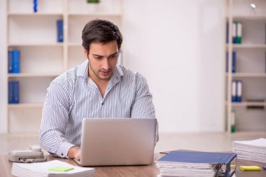 Genç işadamı işyerinde oturuyor.