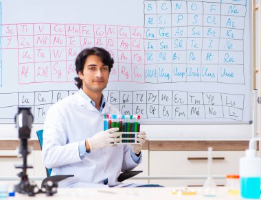 Laboratuvarda çalışan genç kimyager.