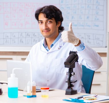 Laboratuvarda çalışan genç kimyager.