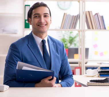 Ofisteki genç ve yakışıklı çalışan.