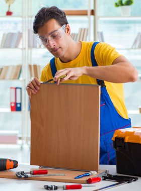 Mobilya marangozu atölyede çalışıyor.